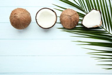 Olgunlaşmış hindistancevizi palmiye ile yapraklar üzerinde ahşap masa