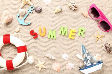 Yaz, deniz kabukları, güneş gözlüğü ve sahil kenarında can simidiyle.