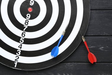 Siyah ahşap masa üzerinde dart ile Dart tahtası