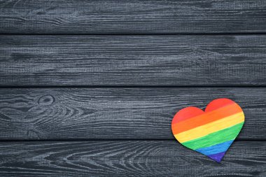 Siyah ahşap masa üzerinde Gökkuşağı kağıt kalp