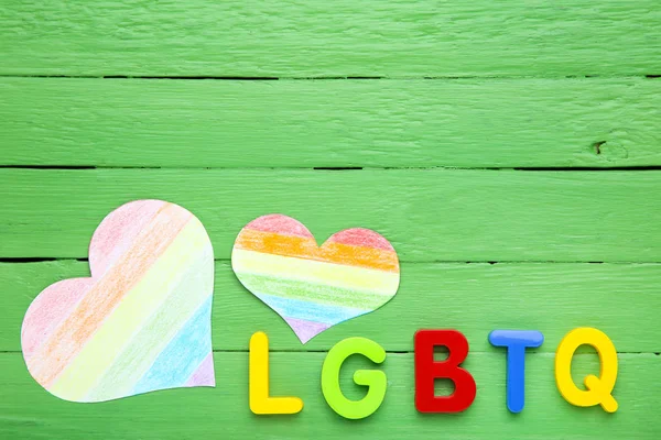 緑の木製のタブルに紙の虹のハートを持つ略語Lgbt — ストック写真
