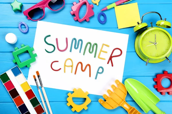 Летний лагерь с пластиковыми игрушками, солнцезащитными очками и красками на блю — стоковое фото