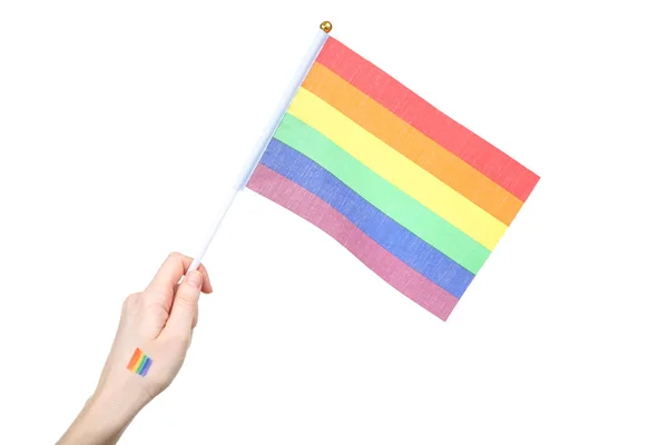 白い背景に虹の旗を持つ女性の手 — ストック写真