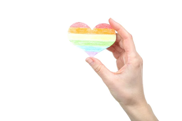 Vrouwelijke hand vasthouden van regenboog papier hart op witte achtergrond — Stockfoto