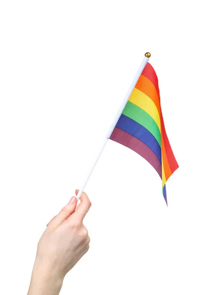 Vrouwelijke hand houden regenboog vlag op witte achtergrond — Stockfoto