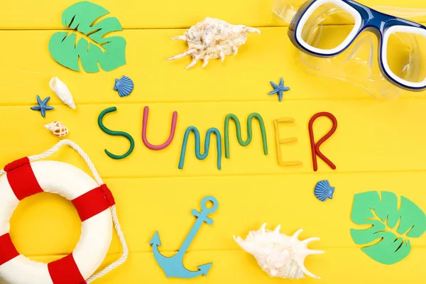Word Summer with seashells, lifebuoy and green paper leafs on ye — Stock Photo, Image