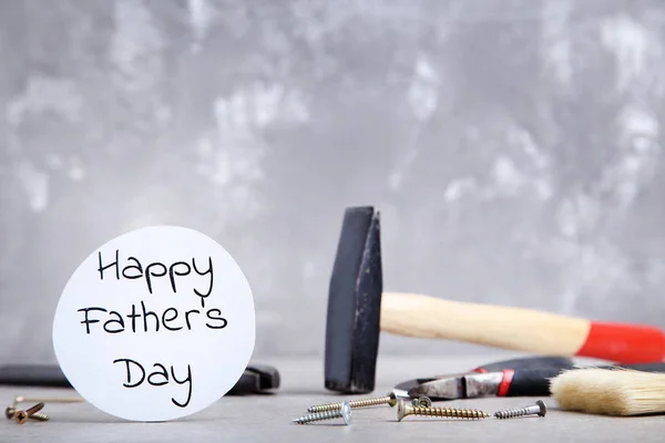 Text Happy Fathers Day with tools on grey background