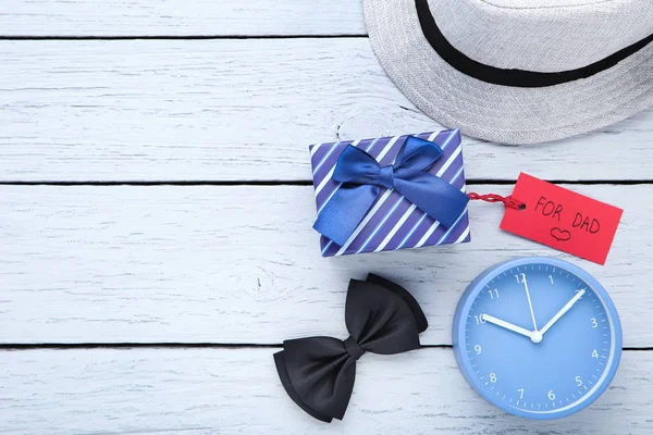 Text For Dad with gift box, clock, bow tie and hat on wooden tab