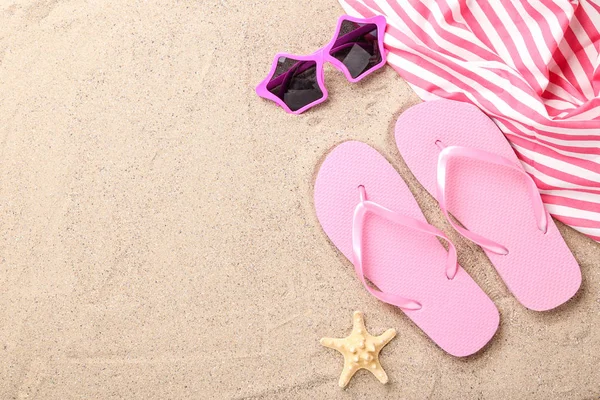 Plaj kumüzerinde denizyıldızı ve güneş gözlüğü ile flip flop çifti