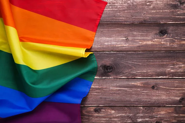 Bandera arco iris sobre mesa de madera marrón — Foto de Stock