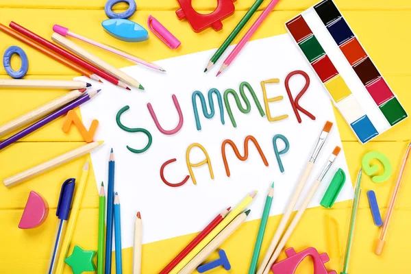 Text letní tábor s hračkami a školními potřebami na žlutém dřevěném — Stock fotografie