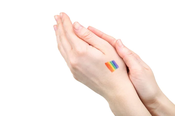 Vrouwelijke hand met tekening regenboog vlag en op witte achtergrond — Stockfoto