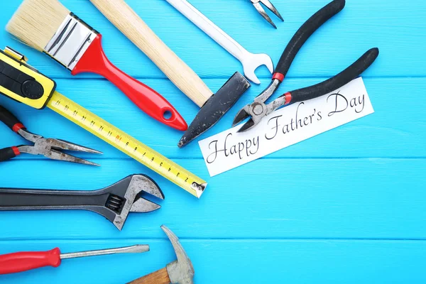 Tekst Happy Ojcowie dzień z narzędziami na niebieskim drewnianym stole — Zdjęcie stockowe
