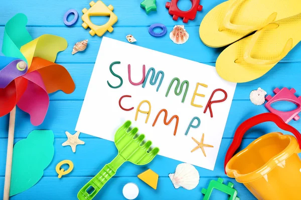 Text-Sommerlager mit Muscheln und Plastikspielzeug auf blauem Holz — Stockfoto