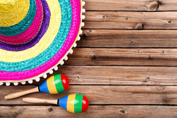 Mexican hat and maracas on brown wooden table — Stock Photo, Image