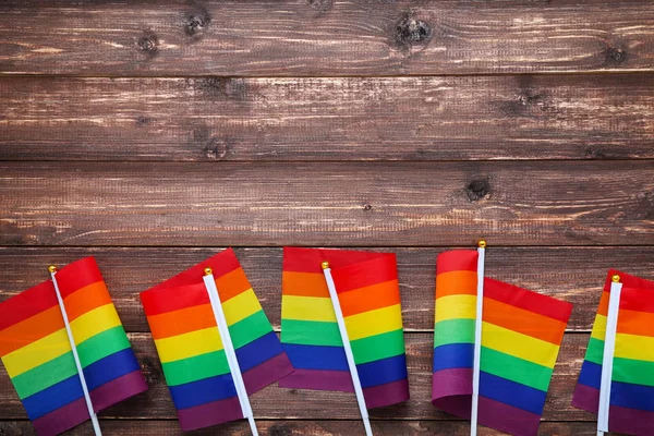 Rainbow flags on brown wooden table — Stock Photo, Image