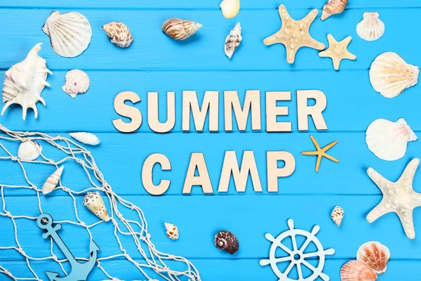 Текст Літній табір з черепашками та рибальською сіткою на синьому дерев'яному т — стокове фото