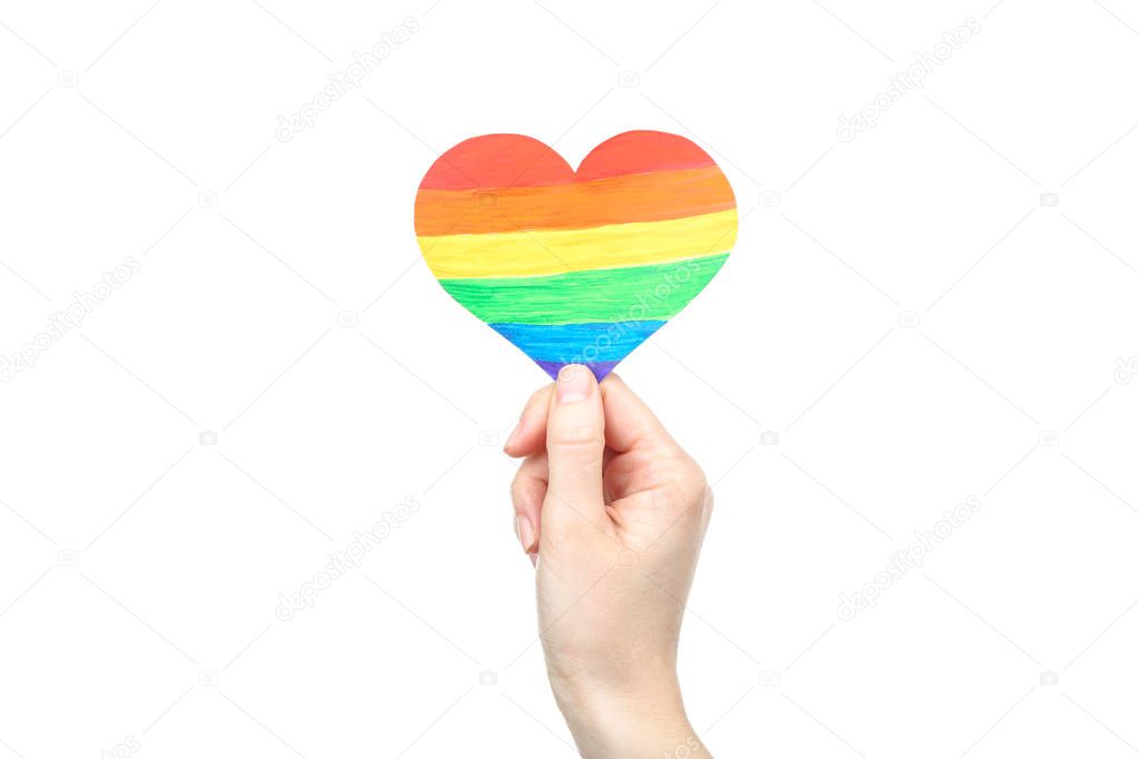 Female hand holding rainbow paper heart on white background