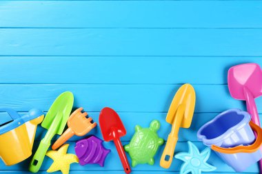 Mavi ahşap masa üzerinde plastik plaj oyuncakları