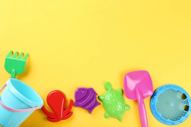 Sarı arka planda plastik plaj oyuncakları