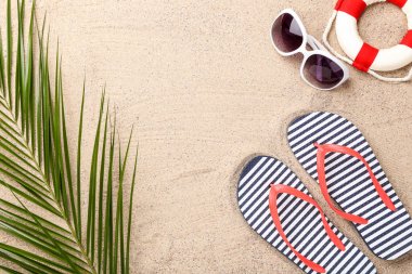 Plaj kumgüneşi ve palmiye yaprağı ile parmak arası terlik çifti