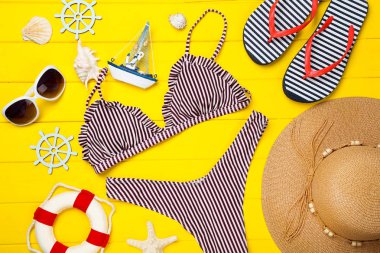 Sarı ahşap ta üzerinde giyim ve deniz kabukları ile Moda mayo