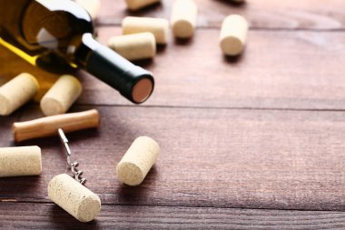 Mantarlar ve tirbuşon kahverengi ahşap masa üzerinde şarap şişesi