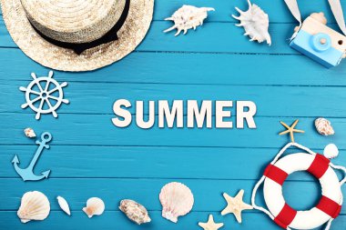 Kelime Yaz deniz kabukları, şapka ve can simidiyle mavi ahşap masa üzerinde