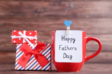 Metin Mutlu Babalar Günü kırmızı fincan ve ahşap sekme üzerinde hediye kutuları ile