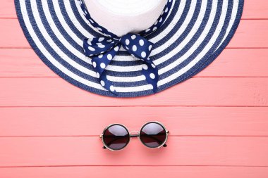 Ahşap masa üzerinde güneş gözlüğü ile Plaj şapkası