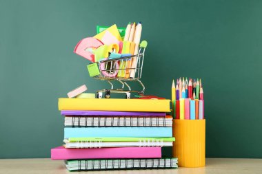 Defter üzerinde kara tahta arka plan ile okul malzemeleri