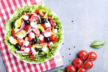 Gri arka plan üzerinde kırmızı peçete kase sebze salatası