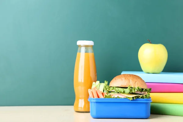 School lunch box met sandwich en een fles SAP op schoolbord — Stockfoto