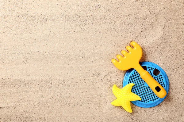 Juguetes de plástico en arena de playa — Foto de Stock