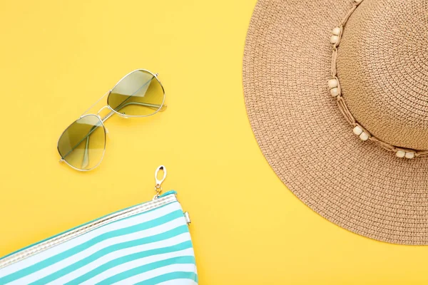 Plážový klobouk s pytlem a slunečními brýlemi na žlutém pozadí — Stock fotografie