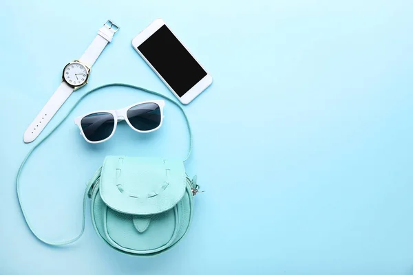 Модна сумка зі смартфоном, сонцезахисними окулярами та наручниками дивитися на b — стокове фото