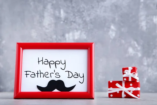 Texto Feliz Día de los Padres con pequeñas cajas de regalo sobre fondo gris — Foto de Stock