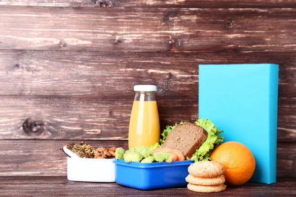 Шкільна обідня коробка з бутербродом та овочами на дерев'яному столі — стокове фото