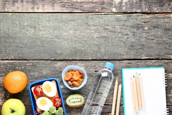 Σχολικό κουτί μεσημεριανού γεύματος με φρούτα και σημειωματάρια σε ξύλινο τραπέζι — Φωτογραφία Αρχείου