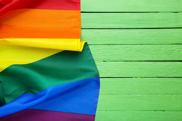 Rainbow flag on green wooden table — Stock Photo, Image