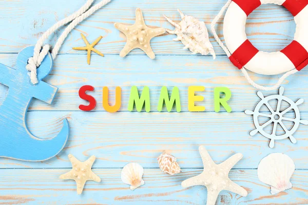 Wort Sommer mit Muscheln, Rettungsring und Anker auf blauem Holz — Stockfoto