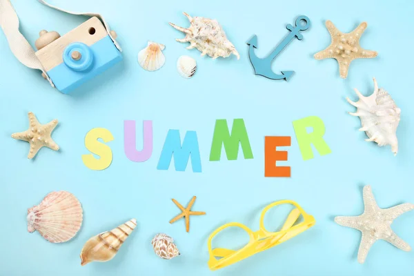 Palavra Verão com conchas, óculos e câmera de madeira em azul ba — Fotografia de Stock