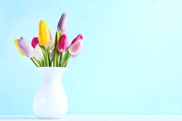Ramo de flores de tulipán en jarrón sobre fondo azul —  Fotos de Stock
