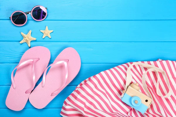 Paar Flip-Flops mit Seesternen, Sonnenbrille und Tasche auf blauem Grund — Stockfoto
