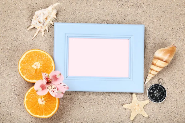 Wooden blank frame with seashells and orange fruits on beach san — ストック写真