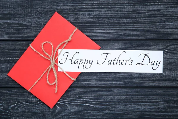 Texto Feliz Día de los Padres con sobre en mesa de madera negro — Foto de Stock