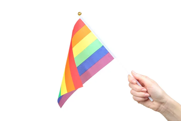 Vrouwelijke hand houden regenboog vlag op witte achtergrond — Stockfoto