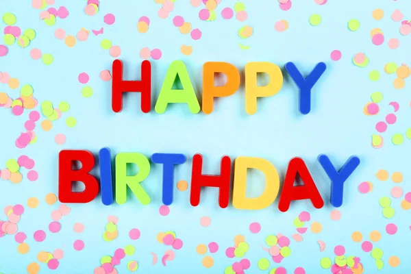 Text Happy Birthday by plastic letters with confetti on blue bac — Stock Photo, Image