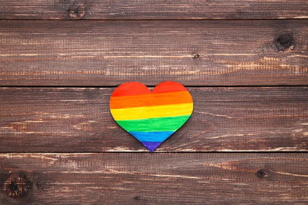 Corazón de papel arco iris sobre mesa de madera marrón —  Fotos de Stock