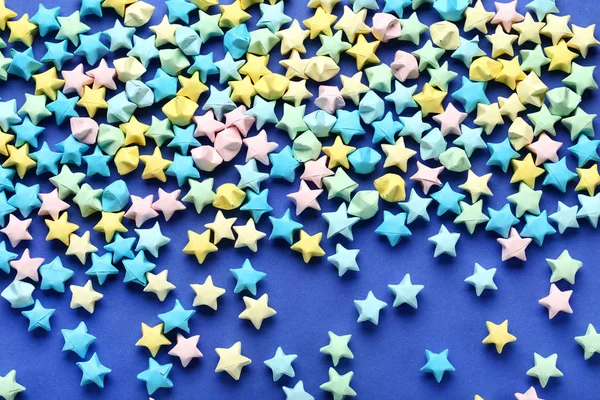 Colorful paper stars on blue background